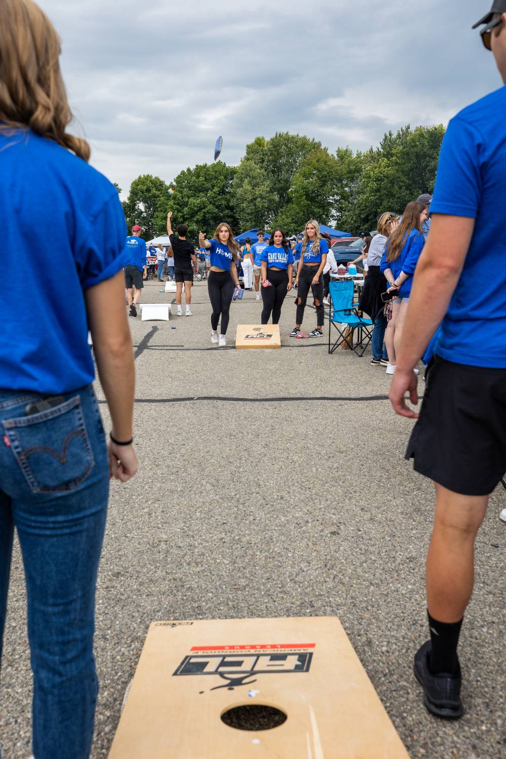 Students play cornhole game during tailgate.